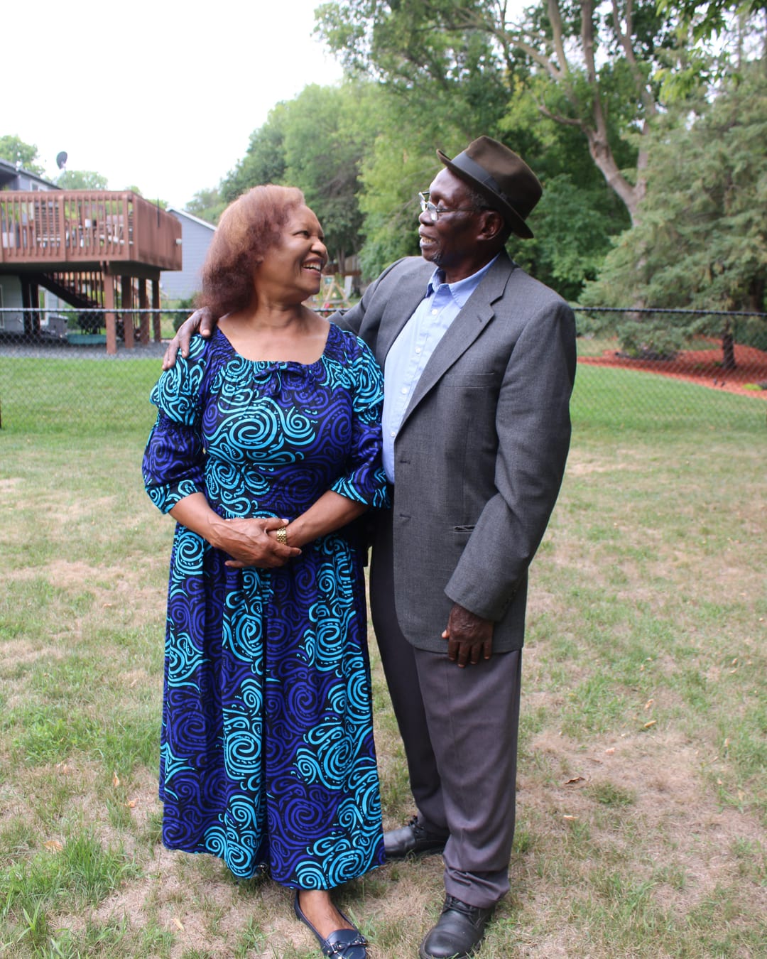An older couple laughing together on a summer lawn