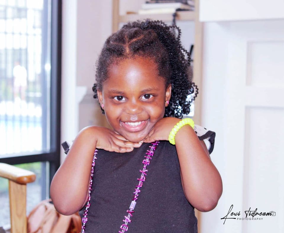 Young girl resting her chin on her hands, smiling indoors