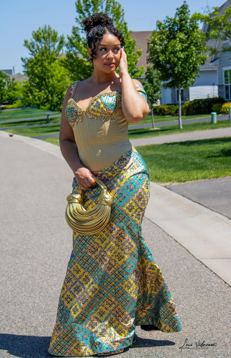 A guest in a teal and gold beaded gown at a cultural celebration